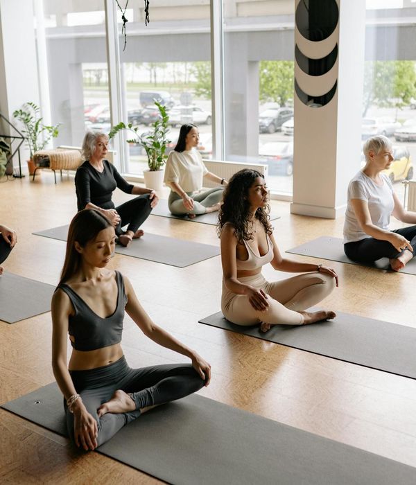 Diverse group of people smiling during a light exercise class.