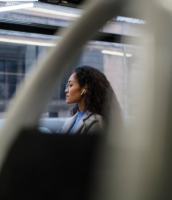 Person enjoying a moment of quiet reflection by a window, looking serene.